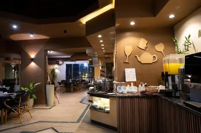 a restaurant with a counter and tables and chairs at Al Dora Resort All Inclusive Hotel in Hurghada