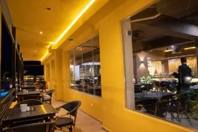 a restaurant with tables and chairs and a yellow wall at Al Dora Resort All Inclusive Hotel in Hurghada