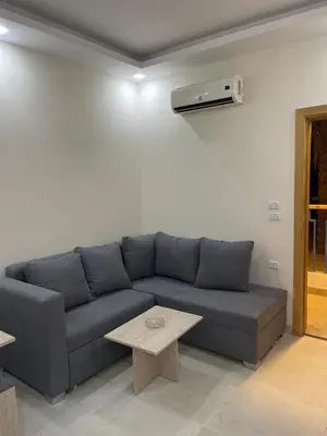 a living room with a blue couch and a table at قرية ميراج باي in Hurghada