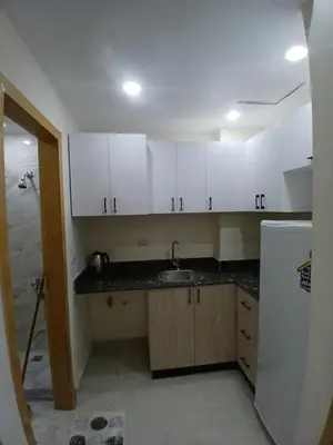 a kitchen with white cabinets and a sink at قرية ميراج باي in Hurghada