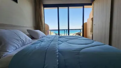 a blue bed in a bedroom with a view of the ocean at Studil for rent old Sheraton 205 in Hurghada