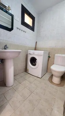 a bathroom with a washing machine and a toilet at Studil for rent old Sheraton 205 in Hurghada