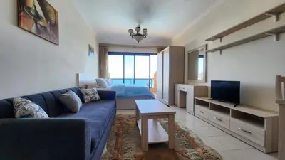 a living room with a blue couch and a tv at Studil for rent old Sheraton 205 in Hurghada