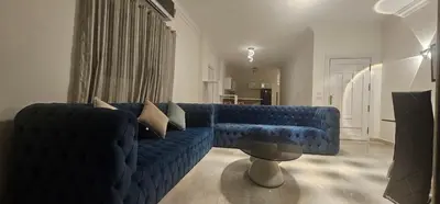 a living room with a blue couch and a table at Sea view apartment 10 , in city center front of the sea F 10 in Hurghada