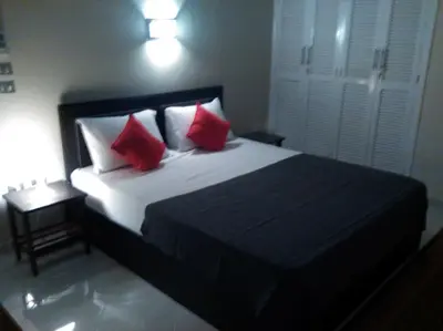 a bedroom with a large bed with red pillows at Desert Rose Apartment in Hurghada