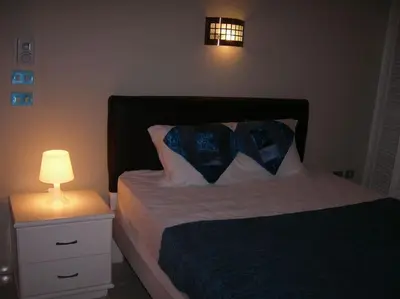 a bedroom with a bed with a lamp on a night stand at Desert Rose Apartment in Hurghada