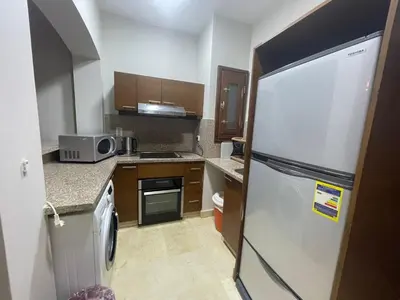 a small kitchen with a refrigerator and a microwave at El gouna , Red sea in Hurghada
