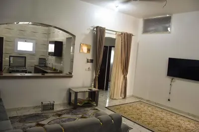 a living room with a couch and a large mirror at Amenirdis Villa in Al Qurnah