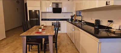 a kitchen with a table with chairs and a counter top at Sea view apartment 09 , in city center in front off the sea 09 in Hurghada