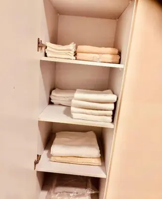 a closet with white towels sitting on shelves at Bosha Aldau Heights Hurghada rent studio in Hurghada