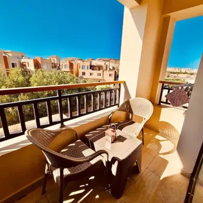 a balcony with chairs and a table on a balcony at Bosha Aldau Heights Hurghada rent studio in Hurghada
