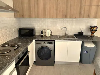 a kitchen with a washing machine and a sink at Unique 2BR Villa - Private Pool In Bali-ElGouna in El Gouna