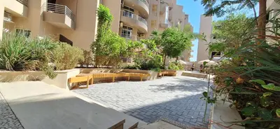 a courtyard with tables and chairs in a building at Cozy 1BR in Princess Resort with Pools & Private Beach in Hurghada