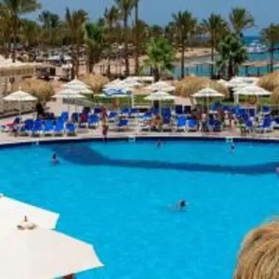 a large blue swimming pool with blue chairs and umbrellas at Mirage Bay Mina Land Resort & Aquapark in Hurghada