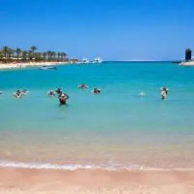 a group of people in the water at the beach at Mirage Bay Mina Land Resort & Aquapark in Hurghada