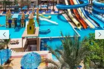 a large swimming pool with a water park at Mirage Bay Mina Land Resort & Aquapark in Hurghada