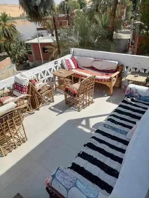 a patio with a table and chairs and a rug at Nubian Life Nile View in Aswan