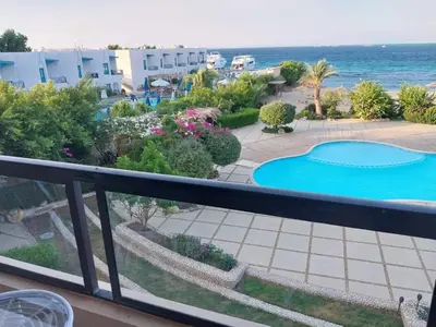 a balcony with a view of a swimming pool and the ocean at Studio for rent 202 in Hurghada