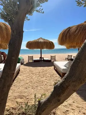 a beach with umbrellas and beds on the beach at Mesca Chalet Soma Bay in Hurghada