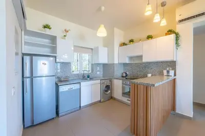a kitchen with white cabinets and a refrigerator at Gouna Retreat 2BR Apt Waterside Hot Tub & Pool in Hurghada