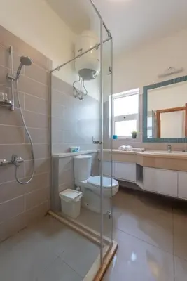 a bathroom with a shower and a toilet and a sink at Gouna Retreat 2BR Apt Waterside Hot Tub & Pool in Hurghada