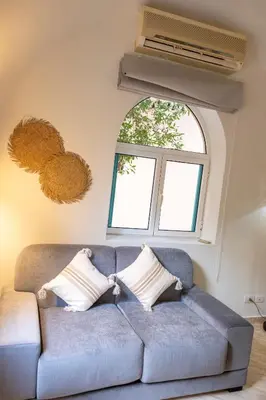 a blue couch in a living room with a window at Studio Serenity Downtown El Gouna in Hurghada