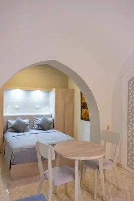 a bedroom with a bed and a table and chairs at Studio Serenity Downtown El Gouna in Hurghada