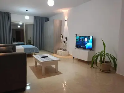 a living room with a couch and a tv in it at Hambra avenue in Hurghada