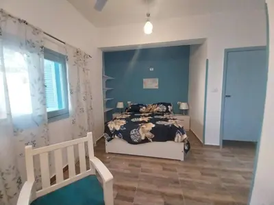 a bedroom with a bed and a blue wall at Ahsaya-house beautiful new home in ‘Ezbet Abu Ḥabashi
