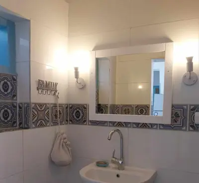 a bathroom with a sink and a mirror at Ahsaya-house beautiful new home in ‘Ezbet Abu Ḥabashi