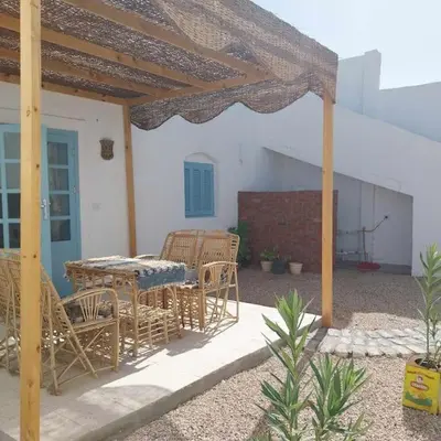 a patio with a table and chairs under a pergola at Ahsaya-house beautiful new home in ‘Ezbet Abu Ḥabashi