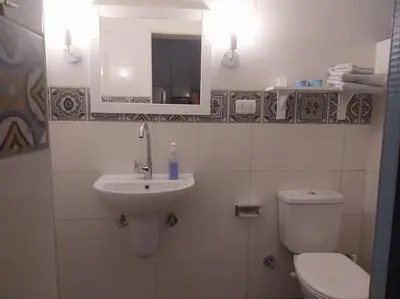 a bathroom with a sink and a toilet and a mirror at Ahsaya-house beautiful new home in ‘Ezbet Abu Ḥabashi