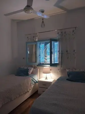 a bedroom with two beds and a window at Ahsaya-house beautiful new home in ‘Ezbet Abu Ḥabashi