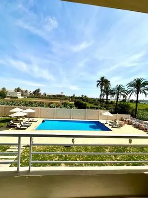 a swimming pool with chairs and umbrellas on a building at Royal Nile Suites - Nile View 2 in Al Aqālitah