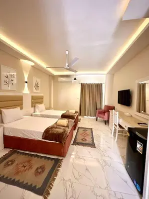 a bedroom with a bed and a desk in a room at Royal Nile Suites - Nile View 2 in Al Aqālitah
