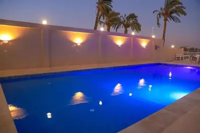 a large blue swimming pool with lights on it at Royal Nile Suites - Nile View 2 in Al Aqālitah
