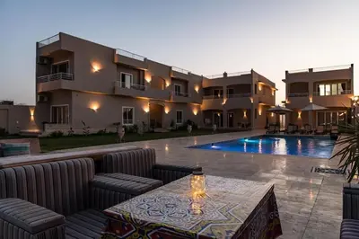 a villa with a swimming pool in front of a house at Royal Nile Suites - Luxury Nile View 1 in Al Aqālitah