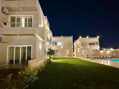 a large white house with a yard at night at Royal Nile Suites - Luxury Nile View 1 in Al Aqālitah