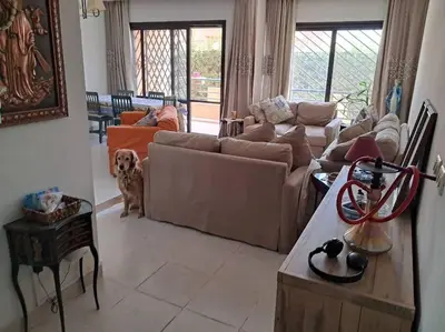 a living room with a couch and a dog in it at Family Fun -Spacious Apartment in Hurghada