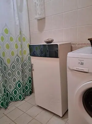 a kitchen with a washing machine and a shower curtain at Family Fun -Spacious Apartment in Hurghada