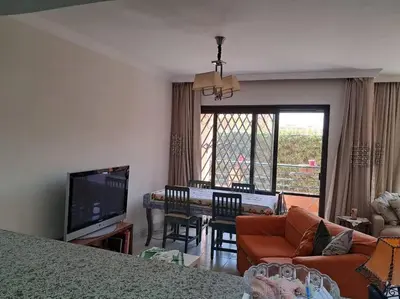 a living room with a couch and a dining room at Family Fun -Spacious Apartment in Hurghada