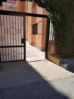 an open gate to a building with a sidewalk at Family Fun -Spacious Apartment in Hurghada