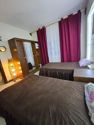 two beds in a room with red curtains at Desert Rose residence 1 bedroom flat in El Kawher in Hurghada