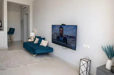 a living room with a blue couch and a flat screen tv at lagoon villa in Hurghada
