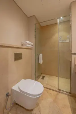 a bathroom with a toilet and a glass shower at Elegant 2BR Plus Nanny Room in Mangroovy Gouna in Hurghada