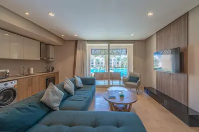 a living room with a blue couch and a table at Elegant 2BR Plus Nanny Room in Mangroovy Gouna in Hurghada