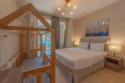 a bedroom with a large bed and a staircase at Elegant 2BR Plus Nanny Room in Mangroovy Gouna in Hurghada