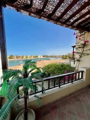 a view of a beach from a balcony with a plant at wast golf y 39-0-2 in Hurghada