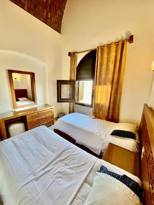 a hotel room with two beds and a window at wast golf y 39-0-2 in Hurghada