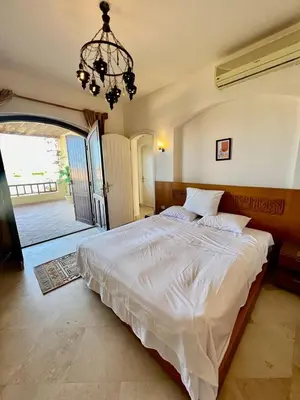 a bedroom with a large white bed with a chandelier at wast golf y 39-0-2 in Hurghada